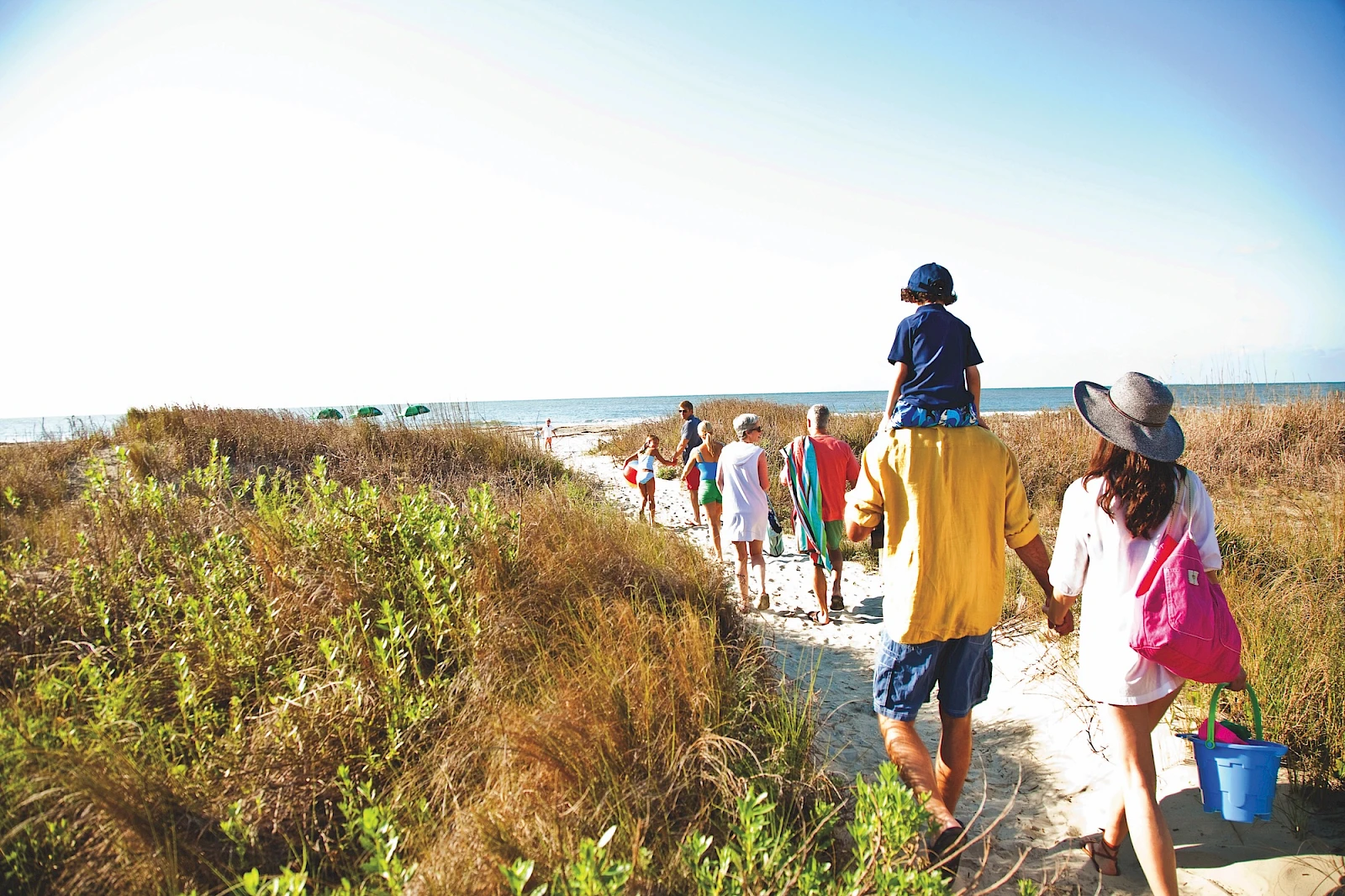 Multi-generational family walking to Isle of Palms beach at Wild Dunes.